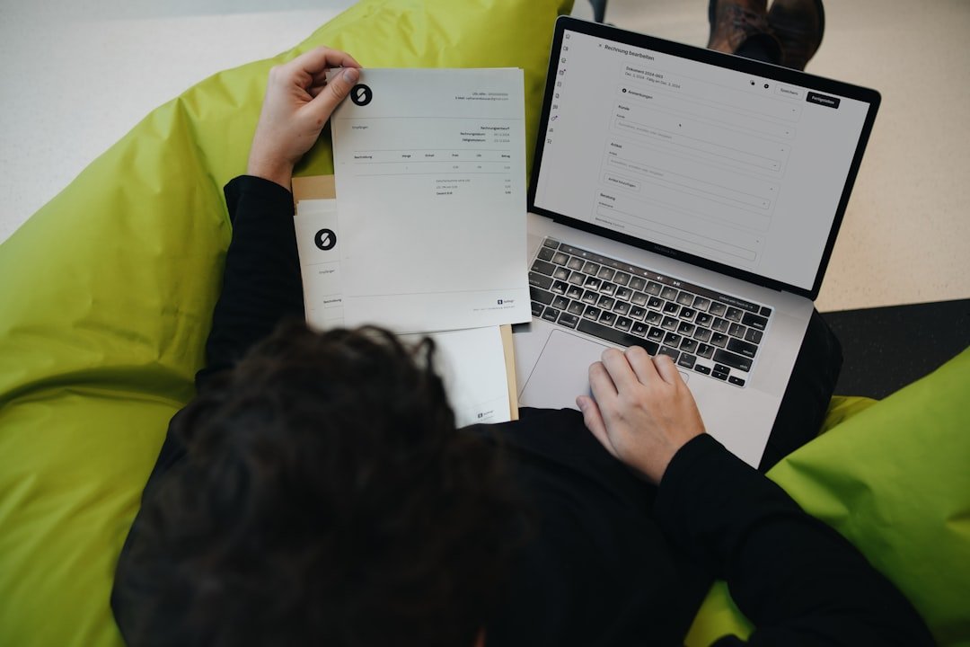 Facture papier et logiciel de facturation en ligne sur un ordinateur portable, illustrant le passage à la facturation électronique en 2026