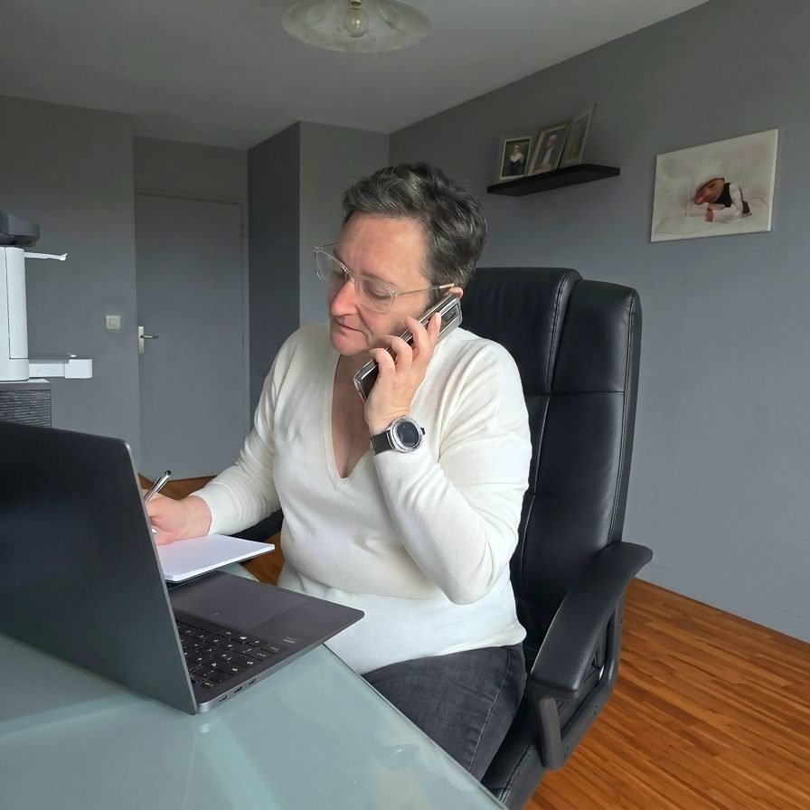 Assistante commerciale au Mans prenant des notes pendant un appel client à son bureau