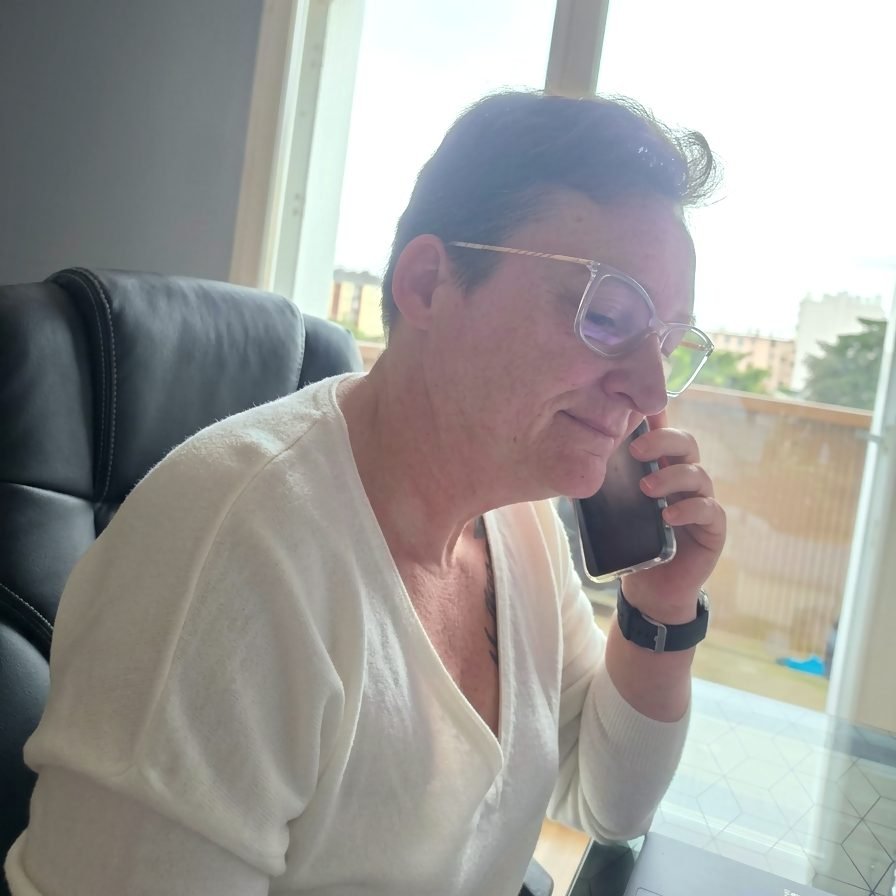 Séverine souriante au téléphone, en train de relancer un client pour une TPE du Mans