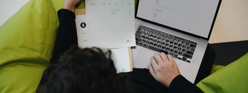 Facture papier et logiciel de facturation en ligne sur un ordinateur portable, illustrant le passage à la facturation électronique en 2026